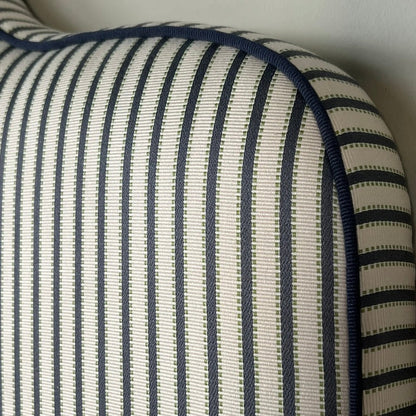 Headboard dressed in Agathe Stripe showing details and the tone-in-tone piping. 