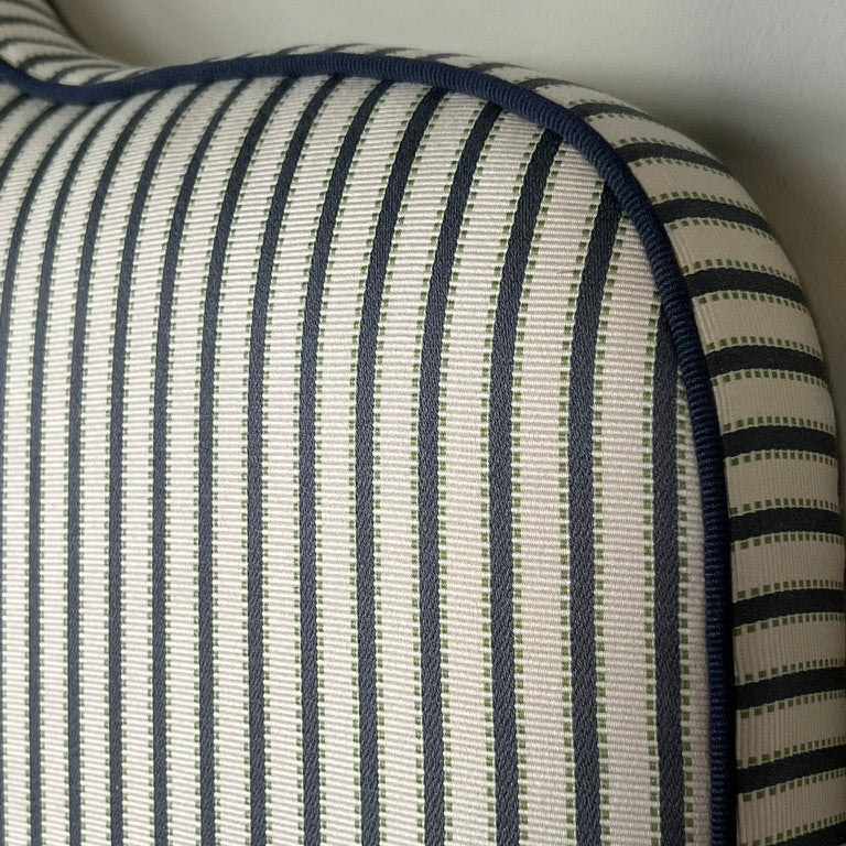 Headboard dressed in Agathe Stripe showing details and the tone-in-tone piping. 