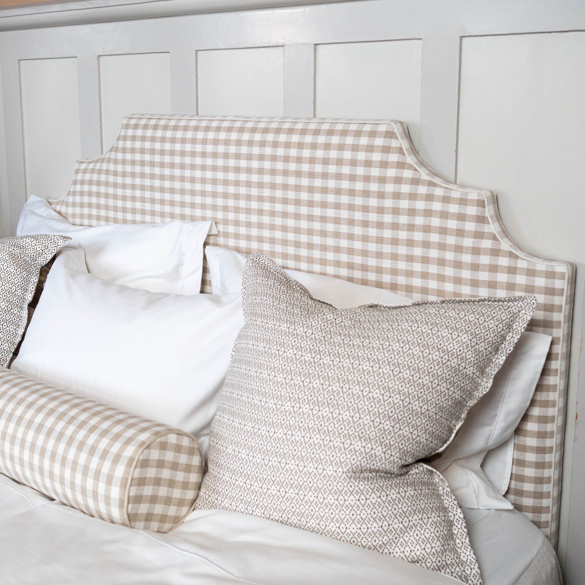 Bed with checkered headboard and pillows in a bedroom setting