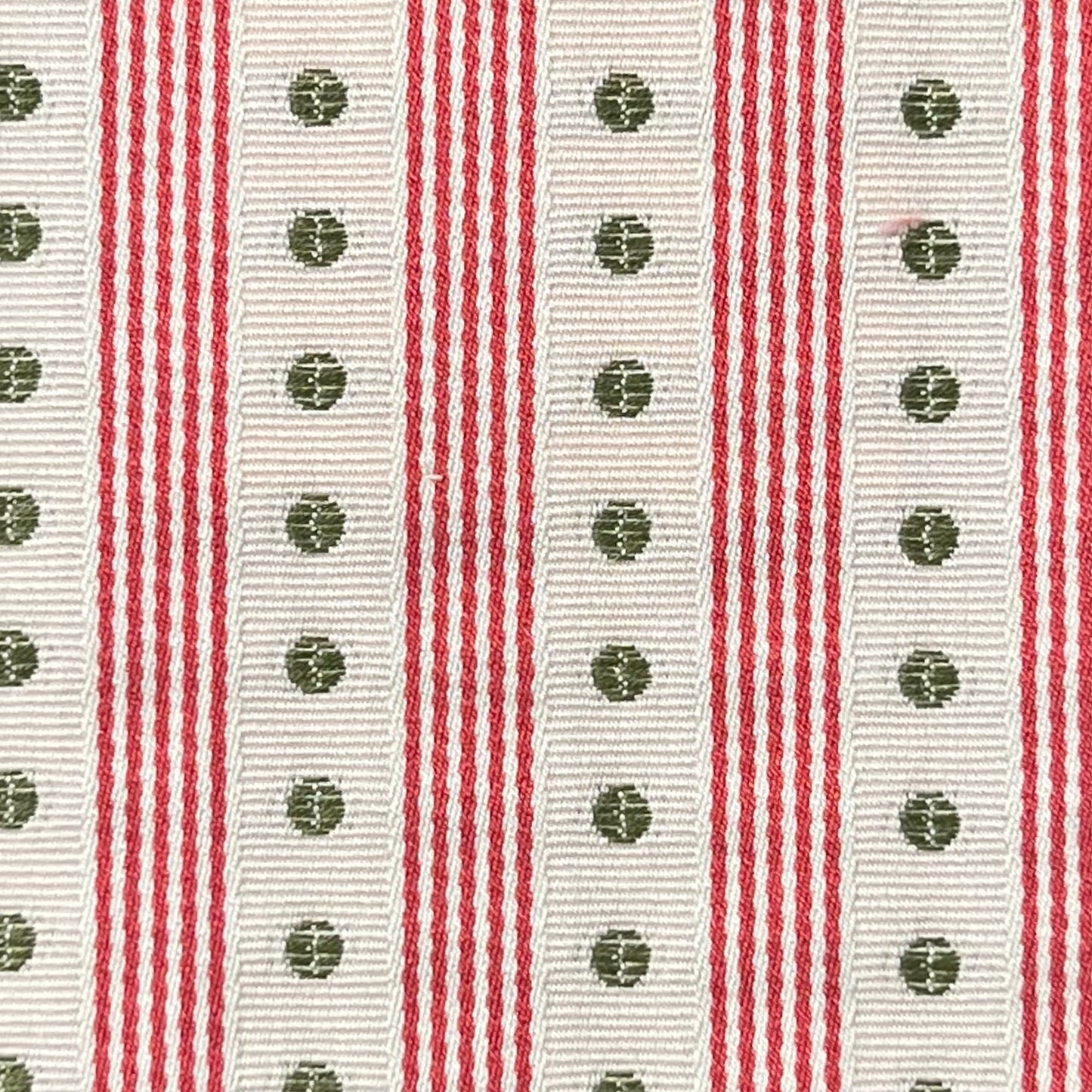 Close-up of a ribbon with red and white stripes and green floral patterns.