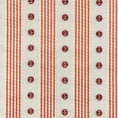 Close-up of a fabric with red stripes and circular patterns on a white background
