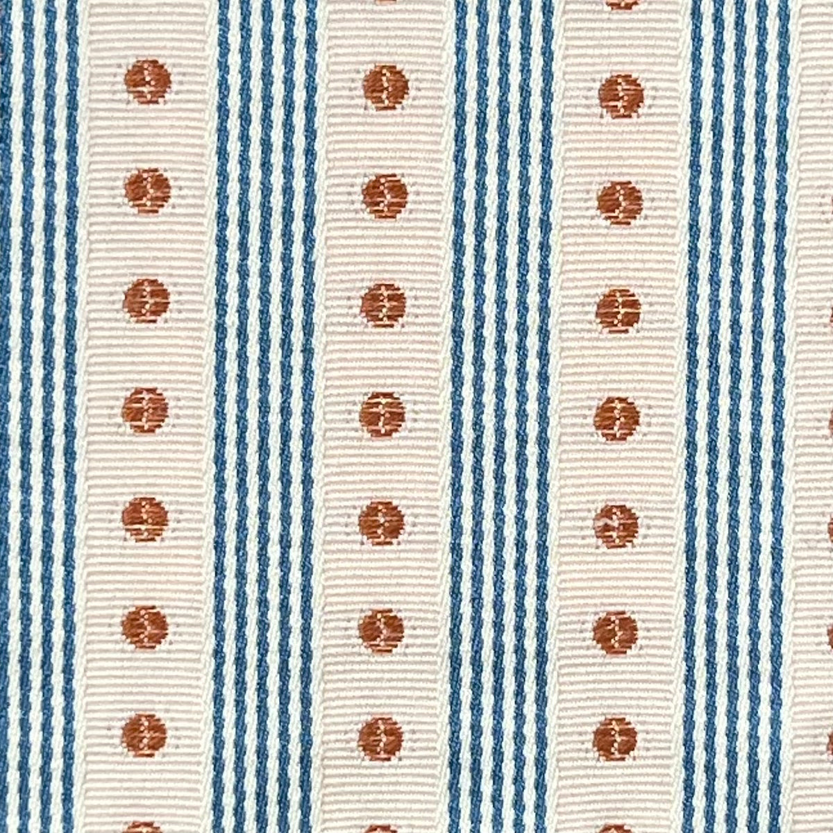 Textile pattern with blue and beige stripes and red circular designs.