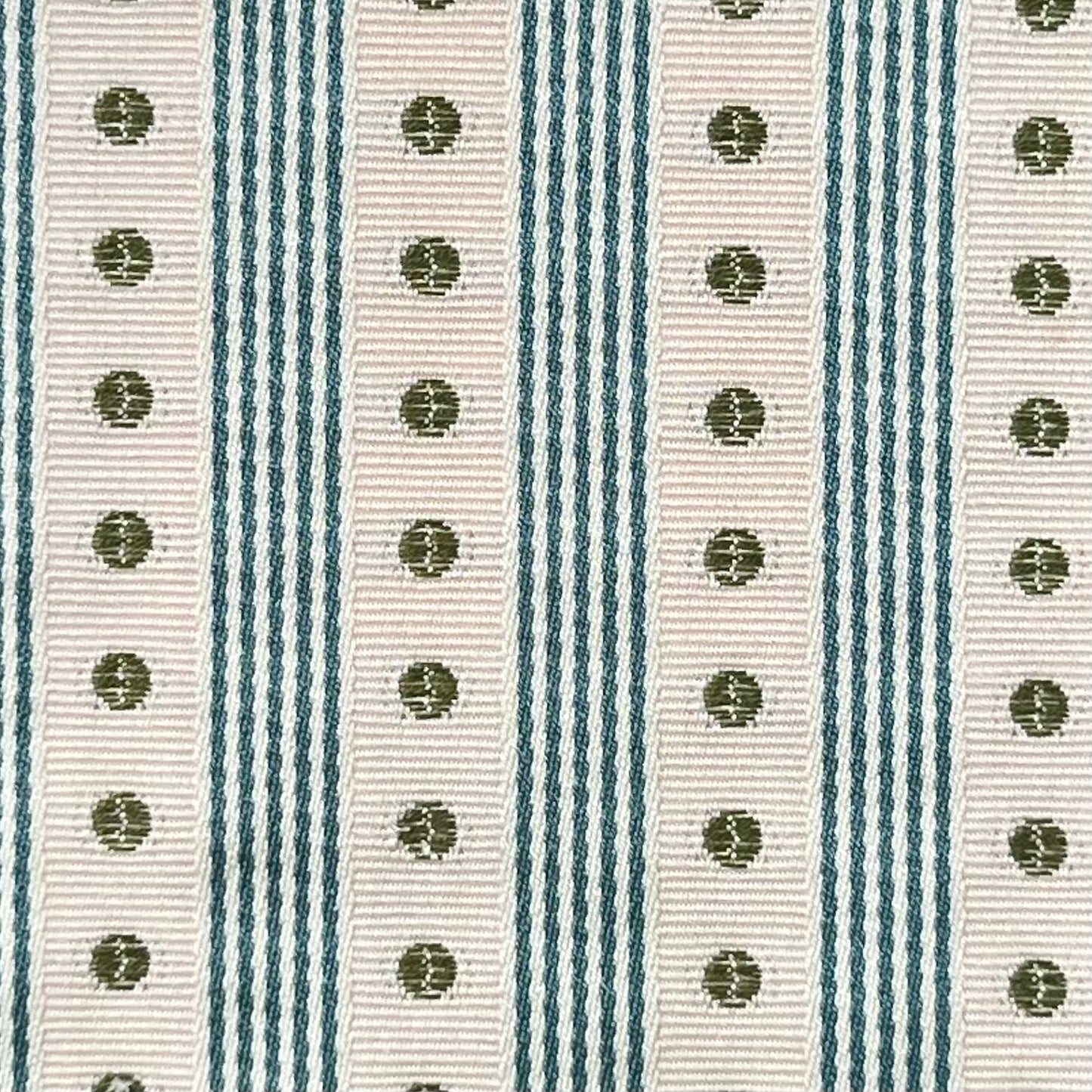 Close-up of a ribbon with green polka dots on a striped background