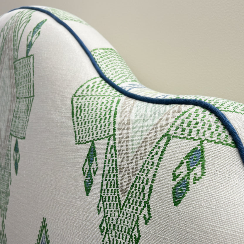 Custom made headboard in green Travelling Light fabric from Christopher Farr. Handcrafted with blue contrast piping . Large scale pattern. 