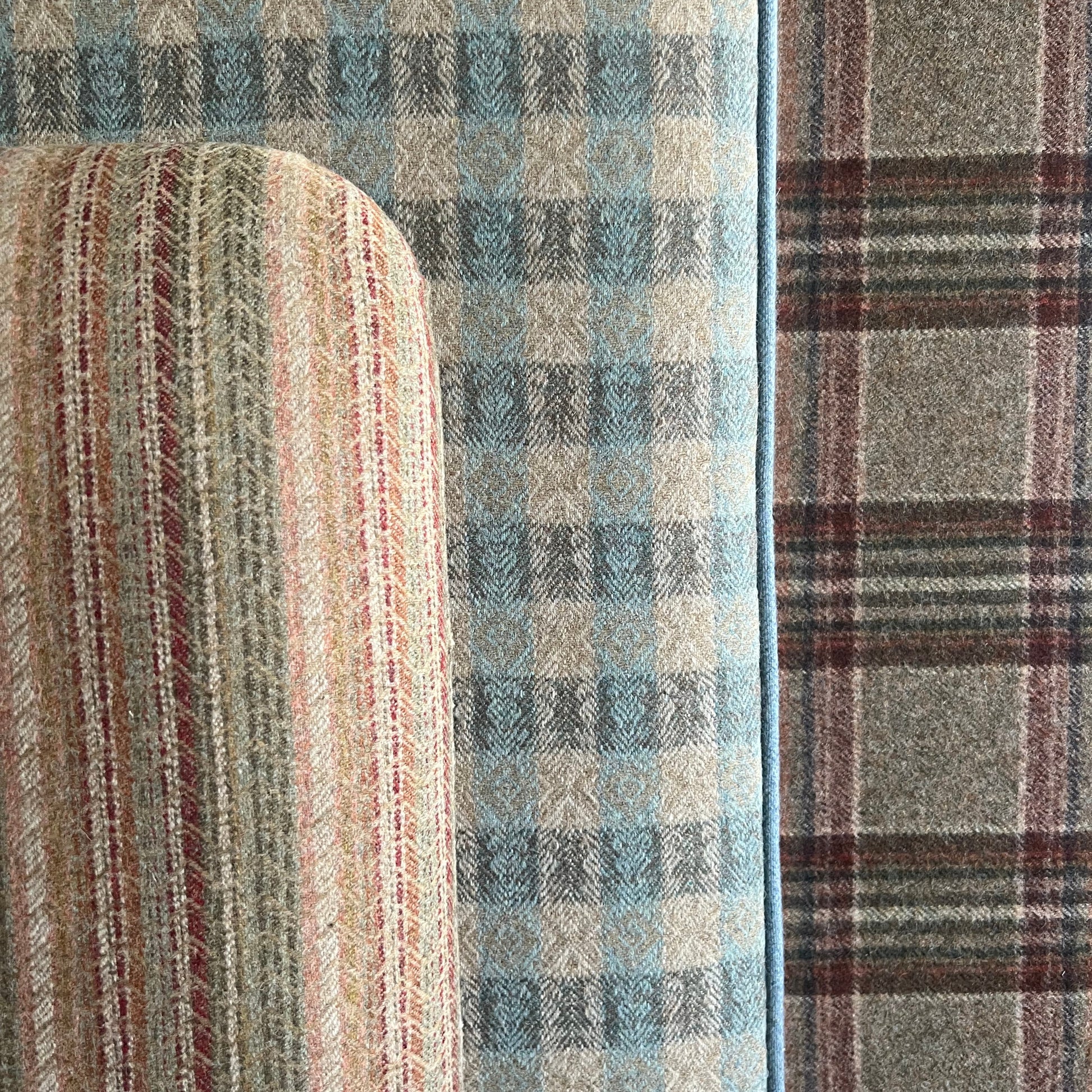 Close-up of a textured fabric with plaid and stripe patterns in blue, brown, and beige.