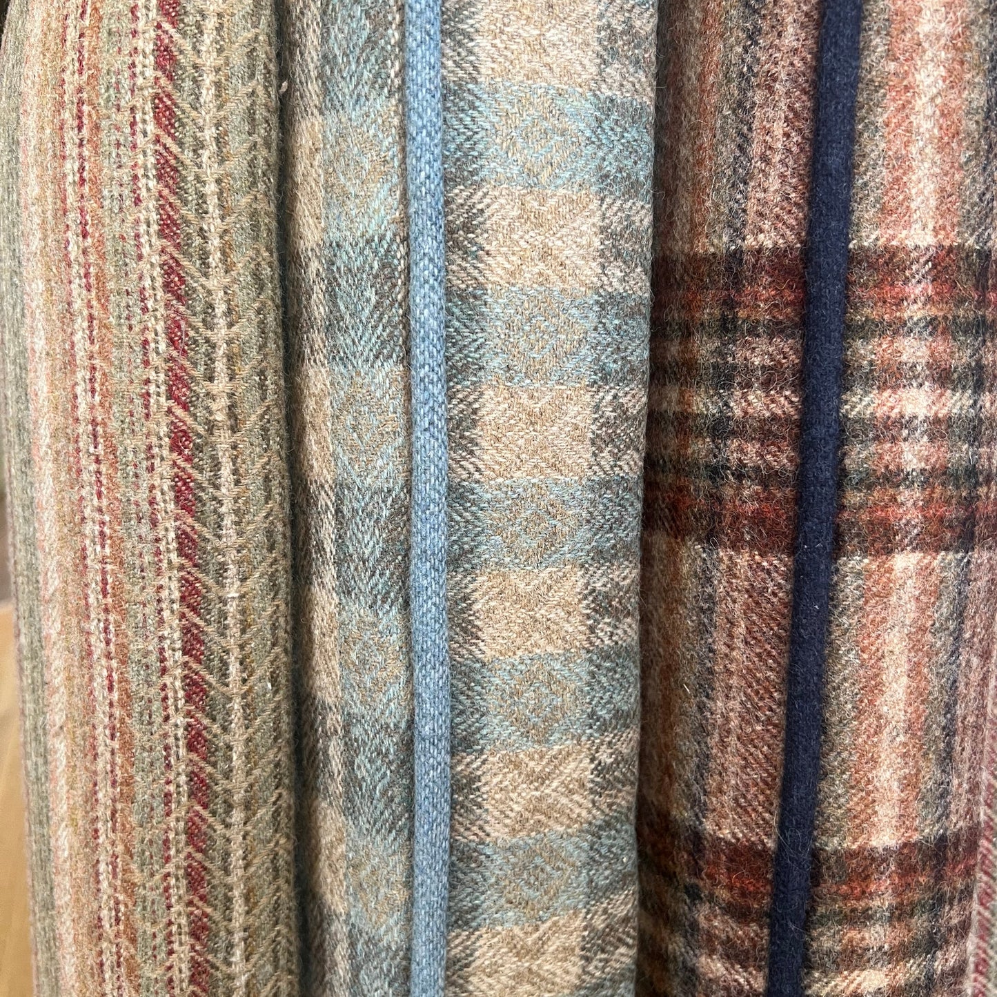 Stack of plaid fabrics in various patterns and colors.