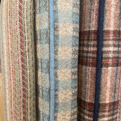 Stack of plaid fabrics in various patterns and colors.