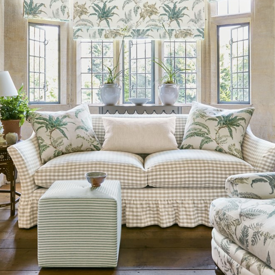 Living room with a checkered sofa, ottoman, and decorative pillows.